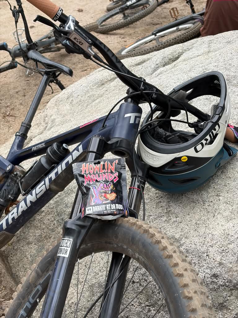 Bag of Barkin' at Da Moon almonds on a mountain bike next to a helmet