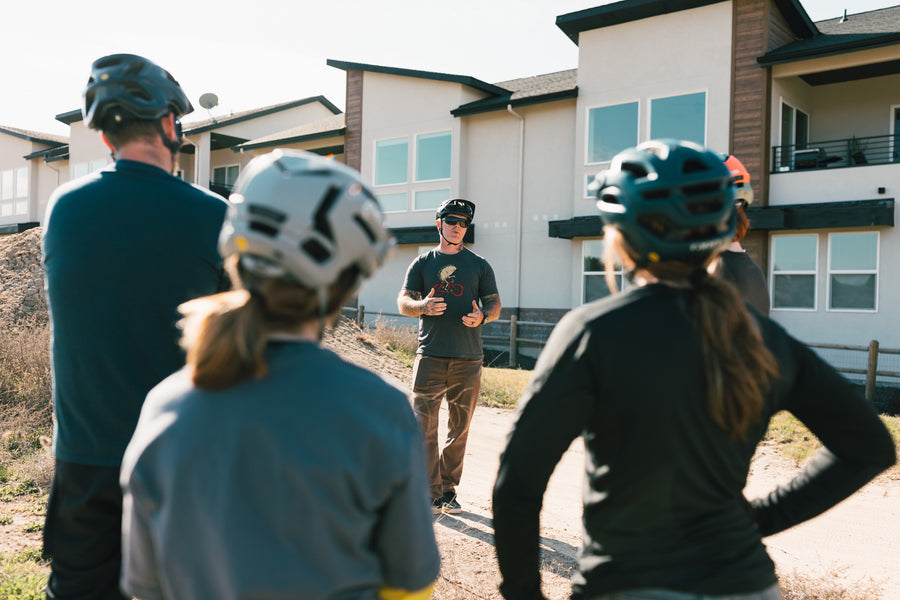 Coach talking with two mountain bike students
