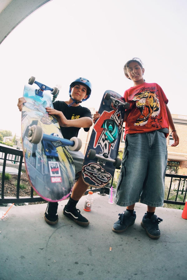 Two young skaters holding their boards